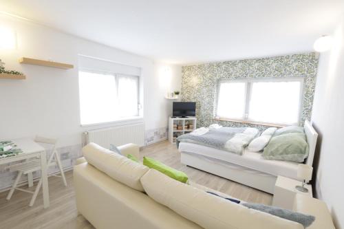 a living room with a bed and a couch at Stardust apartman in Pécs