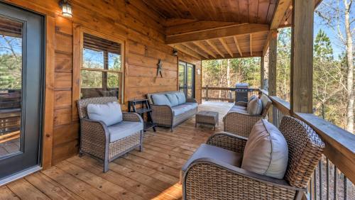 a porch of a cabin with chairs and a grill at Immeasurably More in Mineral Bluff
