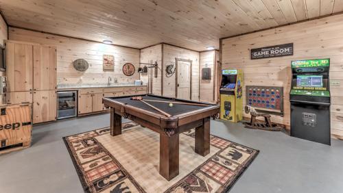 a room with a pool table and a video game at Immeasurably More in Mineral Bluff