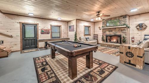 a living room with a pool table and a fireplace at Immeasurably More in Mineral Bluff
