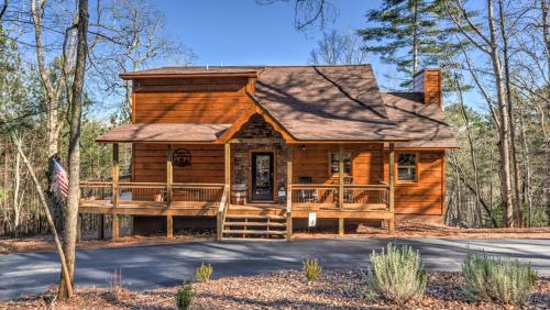 a log cabin in the woods with a porch at Immeasurably More in Mineral Bluff