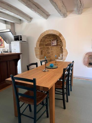une cuisine et une salle à manger avec une table et des chaises en bois dans l'établissement Appartement de charme, à Vitrac