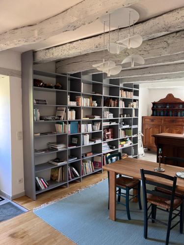 ein Zimmer mit einem großen Bücherregal mit Büchern in der Unterkunft Appartement de charme in Vitrac