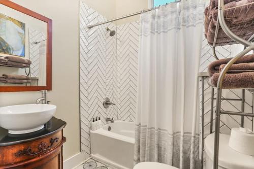 a bathroom with a shower curtain and a sink at Art Filled Sanctuary in the Heart Of Mid City in New Orleans