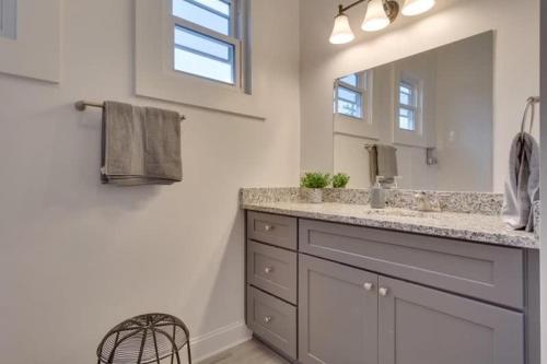 a bathroom with a sink and a mirror at Urban 3 bedroom Local Art Filled Frenchman Oasis in New Orleans