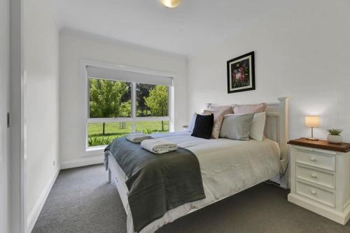 ein weißes Schlafzimmer mit einem Bett und einem Fenster in der Unterkunft Jabulani - Firepit, 5 Acres, Entertainers Paradise in Orange