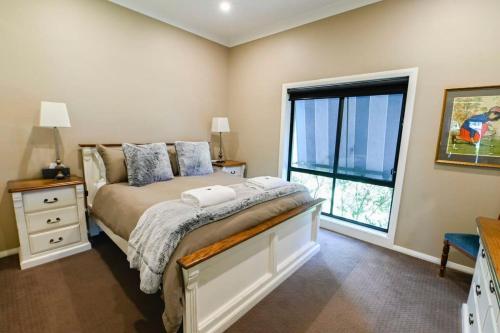 a bedroom with a bed and a large window at Sterling House Spacious Deck BBQ Pet Friendly in Dubbo