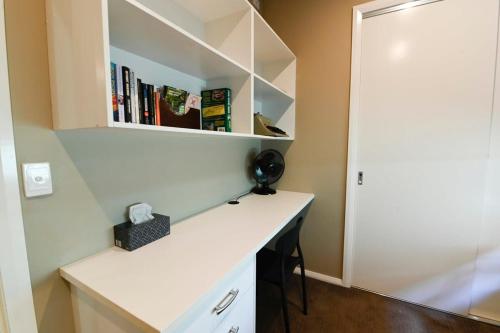 a desk in a room with a book shelf at Sterling House Spacious Deck BBQ Pet Friendly in Dubbo