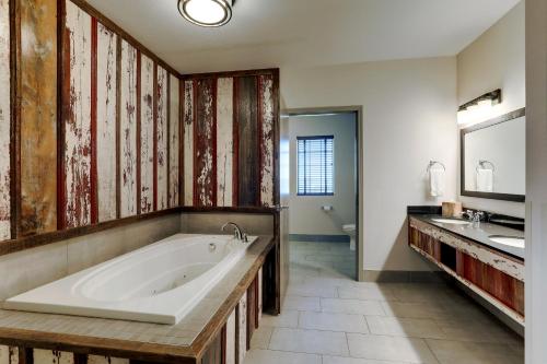 a large bathroom with a tub and two sinks at Stoney Creek Hotel Tulsa - Broken Arrow in Broken Arrow