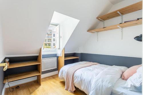 une petite chambre avec un lit et une fenêtre dans l'établissement Appartement Trocadéro - Tour Eiffel, à Paris