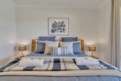 a bedroom with a large bed with blue sheets and pillows at Narambla Estate - Rural Retreat, Luxe Hideaway in Orange