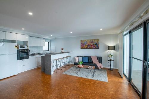 a kitchen and living room with a couch and a table at Cosy Retreat on Naman - Private & Convenient in Dubbo