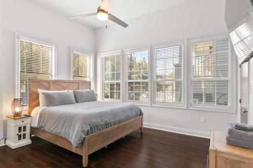 a bedroom with a bed and a bunch of windows at Modern pristine stunning 2BD Garden District Apt in New Orleans