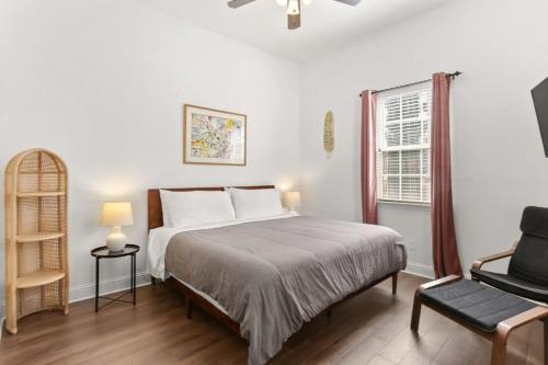 um quarto com uma cama, uma cadeira e uma janela em Fabulous Classy and Comfy 3BD 2BA Home and Parking em Nova Orleans
