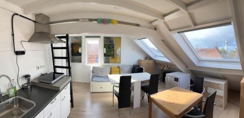 a kitchen and dining area of a tiny house at Studio met eigen badkamer en eigen keuken in Nijmegen