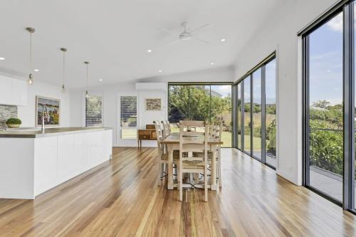a kitchen and dining room with white walls and floor to ceiling windows at The Entertainer - 5 Bed 5 Bath, 3 Storey Retreat in Orange