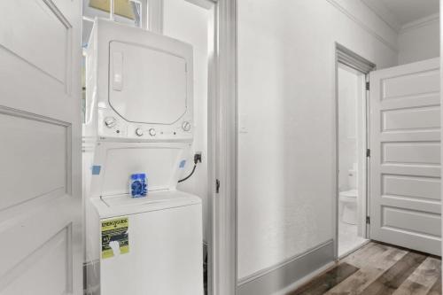 a bathroom with a washer and dryer next to a door at Spacious Mid City 1BD On The Canal Streetcar Line in New Orleans