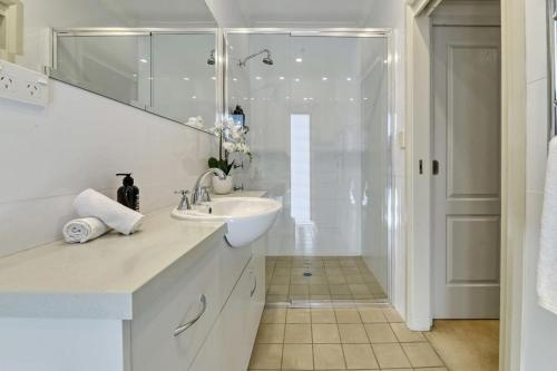 a white bathroom with a sink and a shower at The Sampson Haven - Luxe CBD Getaway, Dog Friendly in Orange
