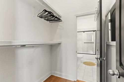 a bathroom with white walls and a staircase with black shoes at Garden District 3BD 2BA Parking Stylish & Unique in New Orleans