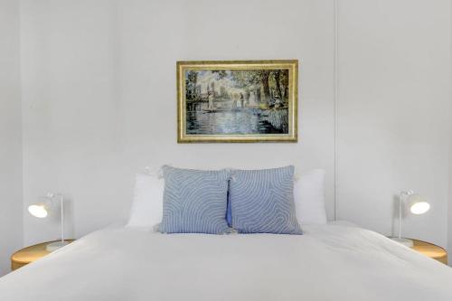 a bedroom with a white bed with a picture on the wall at Hope St Cottage - Elegant & Cosy, Sleeps 6 in Bathurst