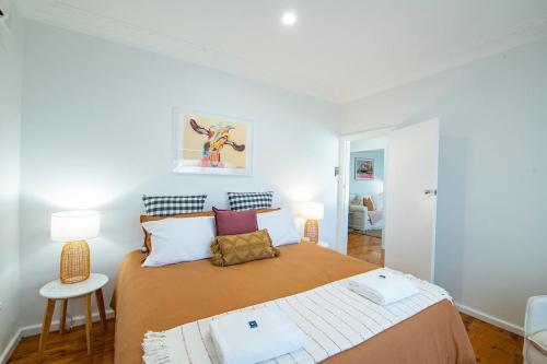 a bedroom with a large bed and two lamps at Cobbora Cottage - Sleek & Stylish, Near Hospital in Dubbo