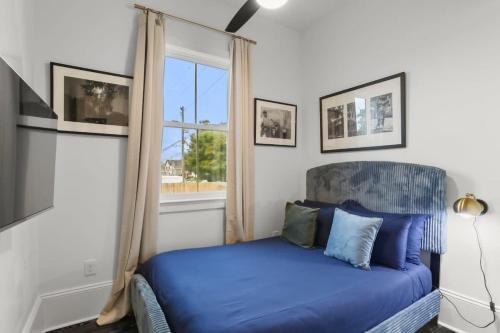 Un dormitorio con una cama azul y una ventana en Luxury 4BD with Pool and off street parking en Nueva Orleans