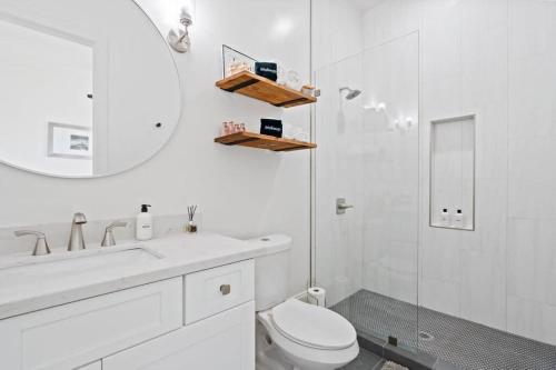a bathroom with a sink and a toilet and a mirror at Elegant 4bd with Pool and Off Street Parking in New Orleans