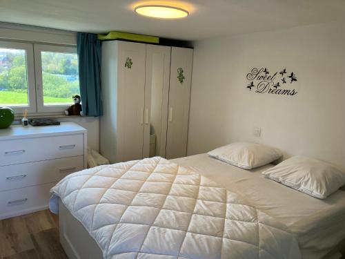 a bedroom with a large white bed and a window at Lovely Acacia in De Haan