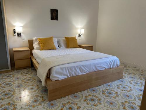 a bedroom with a large bed with yellow pillows at Villa Paola by the sea in Cozze