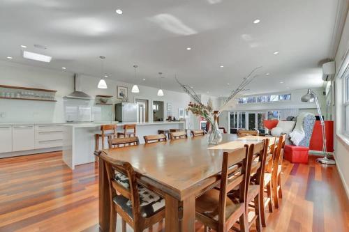 a kitchen and dining room with a wooden table and chairs at Art House on Anson - Artistic Haven, Spa, Pets in Orange