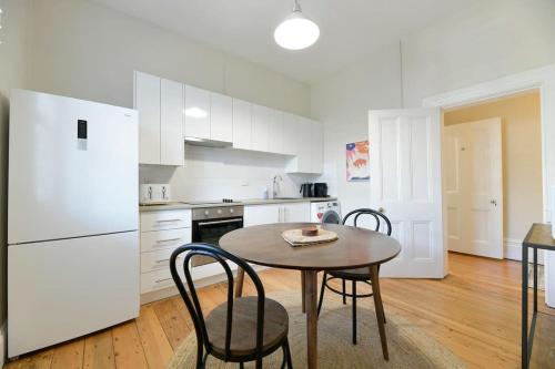 a kitchen with a table and chairs and a white refrigerator at Hope St Cottage I - Historic Haven, Mountain Views in Bathurst