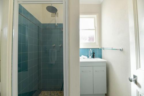 uma casa de banho com um chuveiro e um lavatório. em Hope St Cottage II - Timeless & Serene Sanctuary em Bathurst