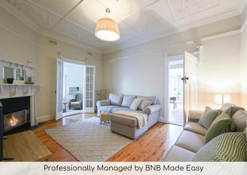 a living room with a couch and a fireplace at Bultje Bliss - CBD Haven, 1920s Timeless Charm in Dubbo
