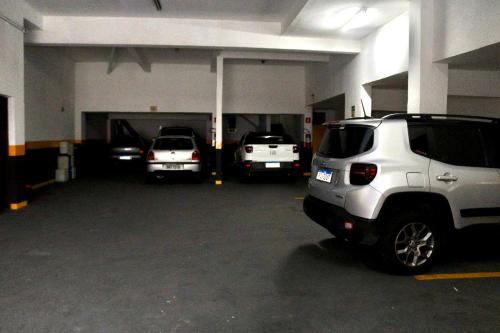 a garage with three cars parked in it at GM Hotel SP in Utinga