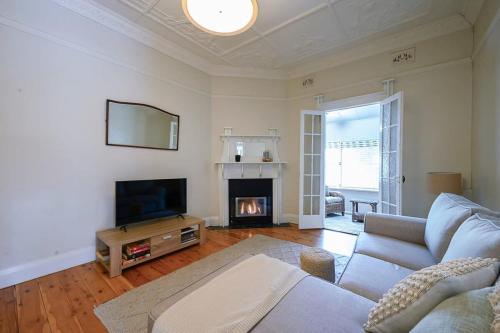 a living room with a couch and a fireplace at Bultje Bliss - CBD Haven, 1920s Timeless Charm in Dubbo