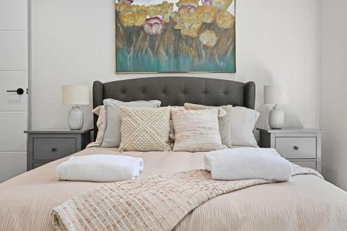 um quarto com uma cama grande com almofadas e um quadro em Bligh St Bliss - Ideal for Families, Mountain Views em Orange