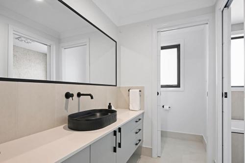 uma casa de banho com um lavatório preto e um espelho em Bligh St Bliss - Ideal for Families, Mountain Views em Orange