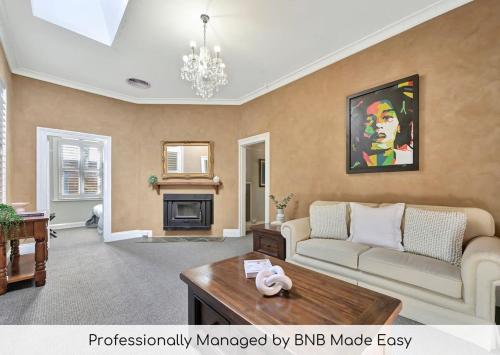 a living room with a couch and a table at Heritage Charm on Hill - Tree-Lined Walk to Town in Orange