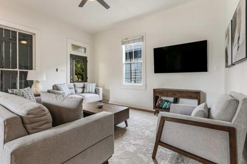 a living room with two couches and a flat screen tv at 5Bed StreetCar Retreat w Outdoor Entertaining in New Orleans