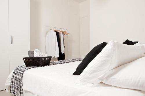a white bed with a black and white blanket at Palazzo Talenti 1907 in Trieste