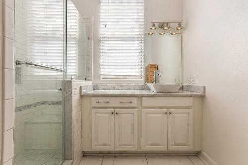 a white bathroom with a sink and a shower at 5Bed StreetCar Retreat w Outdoor Entertaining in New Orleans