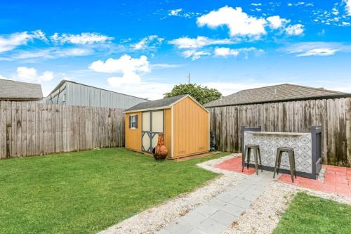 a backyard with a wooden fence and a shed at 5Bed StreetCar Retreat w Outdoor Entertaining in New Orleans