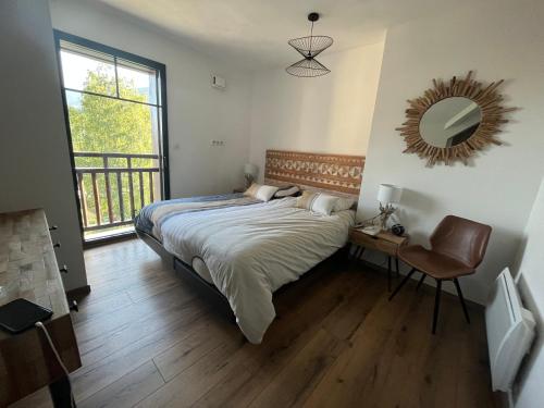 a bedroom with a bed with a mirror and a chair at T4 Saint Lary in Saint-Lary-Soulan