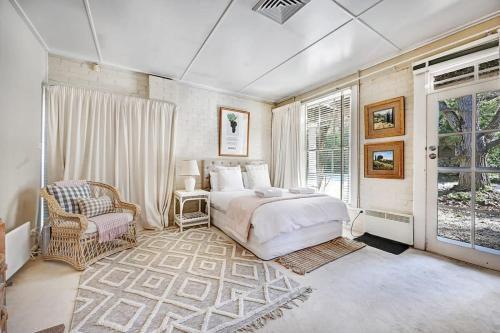 奧蘭治的住宿－The Garden Flat - Mayfield Vineyard Orange，卧室配有床、椅子和窗户。