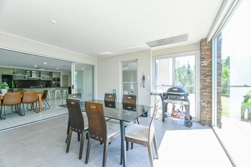 a kitchen and dining room with a glass table and chairs at Southlakes Haven - Lake Views, Pet Friendly in Dubbo