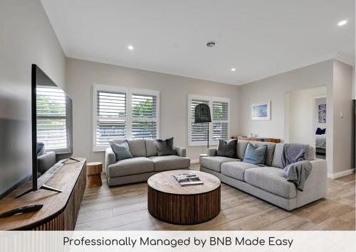 a living room with a couch and a tv at Paradise on Prince - Sleek & Stylish, Dog Friendly in Orange