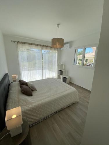 une chambre avec un grand lit et une grande fenêtre dans l'établissement Villa Piazzola, à Petreto-Bicchisano