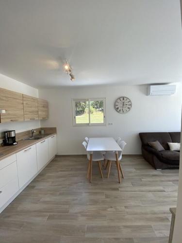 une cuisine et une salle à manger avec une table et une horloge dans l'établissement Villa Piazzola, à Petreto-Bicchisano