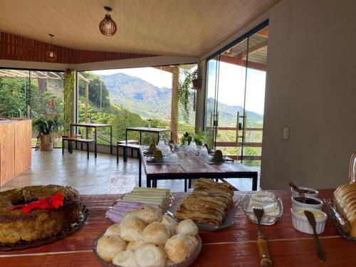 a table with food on it in a room with a view at Chalés Família Onofre in Divisa