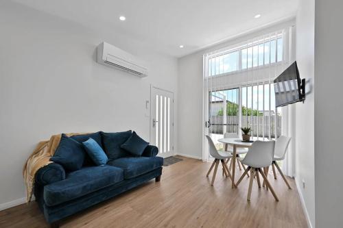 a living room with a blue couch and a table at The Elm Apartments - The Yellow Room in Orange